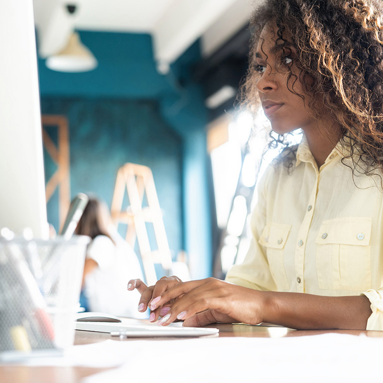 Young black businesswoman in office working on laptop