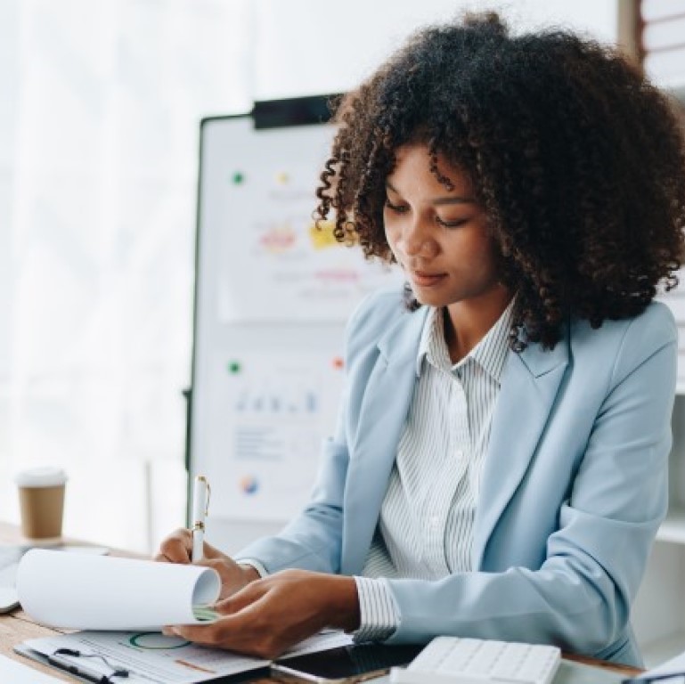 Young woman completing paperwork at a desk