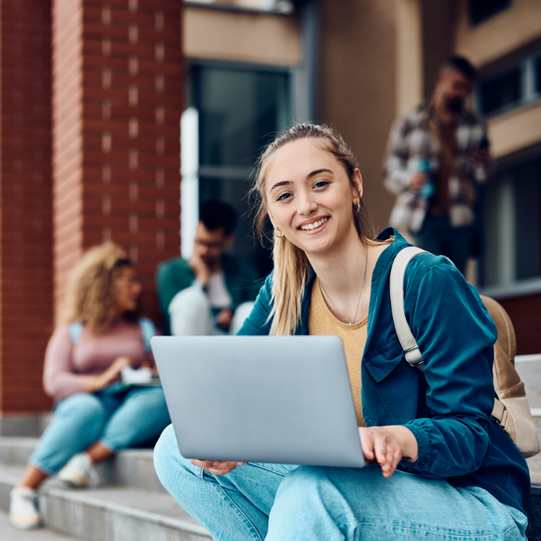 Young woman sitting on a bench and using laptop